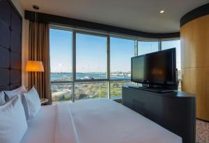 イスタンブールにあるダブルツリー バイ ヒルトン イスタンブール モダのベッド1台、薄型テレビが備わるホテルルームです。