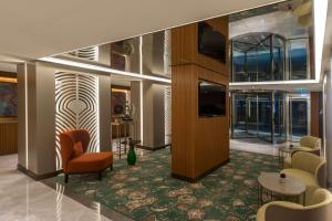a lobby with chairs and tables and a television at DoubleTree by Hilton Istanbul - Sirkeci in Istanbul