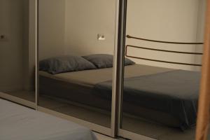 a mirror reflecting a bed in a bedroom at Sunny studio apartment Chiara in Tivat +14 photos