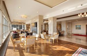 a lobby with tables and chairs in a building at DoubleTree By Hilton Avanos Cappadocia in Avanos
