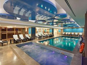 a large pool in a hotel with chairs and tables at DoubleTree By Hilton Avanos Cappadocia in Avanos