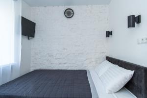um quarto com uma cama com uma parede de tijolos e um relógio em MYFREEDOM Апартаменти метро Берестейська em Kiev
