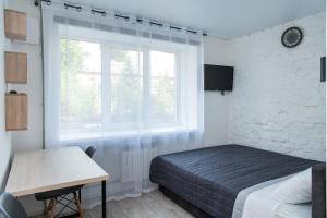 1 dormitorio con cama, ventana y escritorio en MYFREEDOM Апартаменти метро Берестейська en Kiev