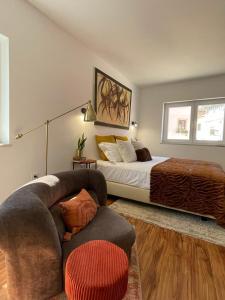 a bedroom with a large bed and a couch at stressfree charm house in Odeceixe