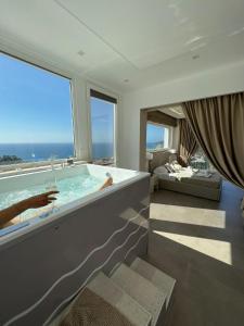 a large bathroom with a soaking tub with a view of the ocean at Miramare Castellabate Resort in Santa Maria di Castellabate