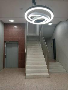 un escalier dans un bâtiment doté d'un grand éclairage dans l'établissement Apartament Słoneczny, à Łódź