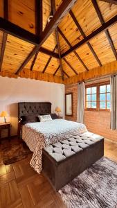 ein Schlafzimmer mit einem großen Bett und einer Holzdecke in der Unterkunft Recanto de Minas in Monte Verde