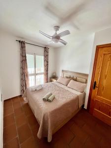 sypialnia z łóżkiem i wentylatorem sufitowym w obiekcie Apartamento en el casco histórico, a 5 min playa. w mieście Conil de la Frontera