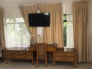 a desk with a television on top of a window at Hotel Zaracay in Santo Domingo de los Colorados