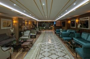 eine Lobby mit blauen Sofas und Tischen in der Unterkunft Doubletree By Hilton Elazig in Elâzığ