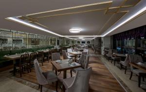Doubletree By Hilton Elazig في إلازِغ: مطعم فيه طاولات وكراسي في الغرفة