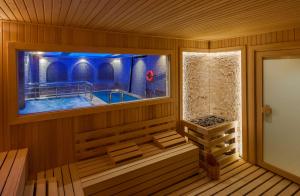 a sauna with a jacuzzi tub with a window at Doubletree By Hilton Elazig in Elazığ