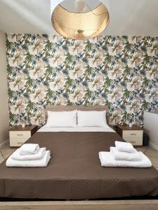 a bedroom with a large bed with towels on it at B&B La Rosa in Antrosano +23 photos