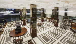 eine Lobby eines Gebäudes mit Tischen und Stühlen in der Unterkunft DoubleTree by Hilton Istanbul-Avcilar in Istanbul