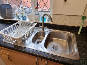 a kitchen sink with a dish drying rack in it at 3 Bedroom House Free Parking & Fast Wi-Fi Spacious near Rochdale Centre in Rochdale