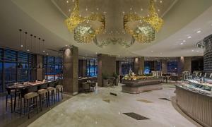 a hotel lobby with a restaurant with a chandelier at Hilton Istanbul Kozyatagi in Istanbul