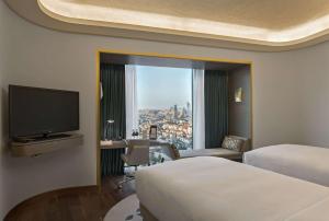 um quarto de hotel com duas camas e uma grande janela em Hilton Istanbul Kozyatagi em Istambul