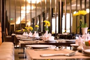 a row of tables in a restaurant with yellow flowers at DoubleTree by Hilton Nairobi in Nairobi