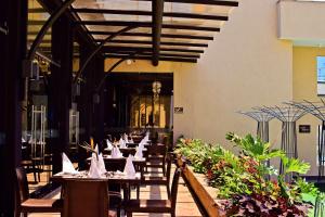 a dining room with tables and chairs and plants at DoubleTree by Hilton Nairobi in Nairobi