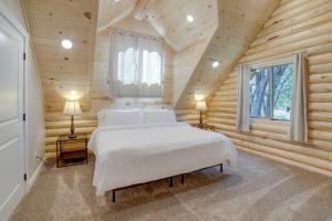 1 dormitorio con 1 cama blanca en una cabaña de madera en Private Riverside Cabin, Golf Across the Street, en Lorenzo