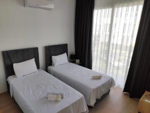 a bedroom with two beds and a large window at Luxury Four seasons Life Ruby Apartment Bogaz in Boğaz +18 photos