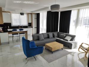 a living room with a couch and a blue chair at Luxury Four seasons Life Ruby Apartment Bogaz in Boğaz
