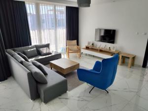 a living room with a couch and a blue chair at Luxury Four seasons Life Ruby Apartment Bogaz in Boğaz