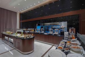 una línea de buffet con platos de comida en un restaurante en Doubletree by Hilton Istanbul Umraniye, en Estambul