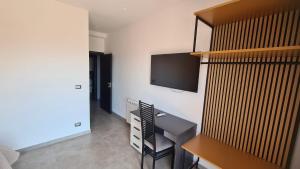 Habitación con TV en la pared y silla en CASA VENEZIANO, en Messina