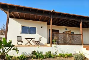 a house with a deck with a table and chairs at Casa Cernicalo in Nazaret