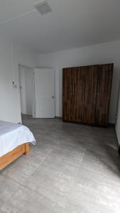une pièce vide avec un lit et des armoires en bois dans l'établissement Haven Green Village, à Grand Gaube