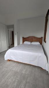 - une chambre avec un grand lit et des draps blancs dans l'établissement Haven Green Village, à Grand Gaube