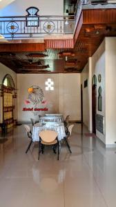 een eetkamer met een tafel en stoelen in een gebouw bij Hotel Garuda in Rambah