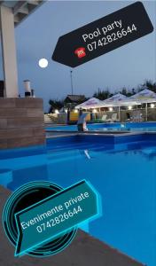 a pool party sign next to a swimming pool at MARADA felix in Hidişelul-de Sus