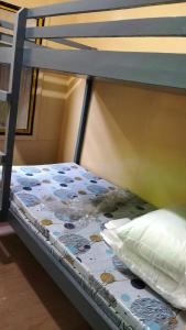 a bunk bed with a pillow and a blanket on it at BNJ Boarding House in Bislig