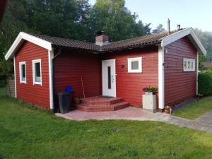 a red house with a white door and a yard at Gästehaus an der Surheide in Ottersberg