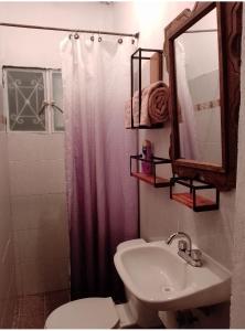a bathroom with a sink and a toilet and a mirror at Casa Itanuni in Santa Lucía