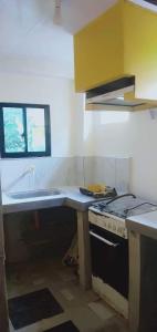 a kitchen with a stove and a counter top at BNJ Boarding House in Bislig