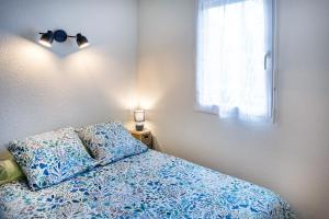 una camera da letto con un letto con lenzuola blu e una finestra di Appart. T 1 Bis, centre ville, entièrement rénové a Lourdes