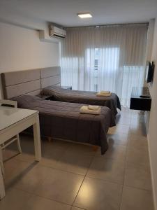 1 dormitorio con 2 camas, mesa y escritorio en I432 en Córdoba