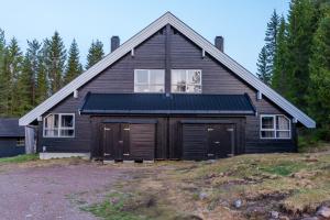 a house with a large garage in front of it at Trysil Alpin 40A in Trysil