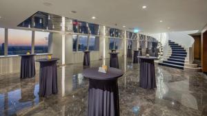 a lobby with a staircase and tables in a building at Hilton Istanbul Maslak in Istanbul
