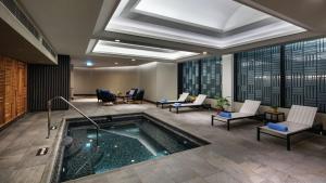 a hotel lobby with a pool with chairs and tables at Hilton Istanbul Maslak in Istanbul