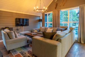 a living room with a couch and chairs and a tv at Trysil Alpin 40A in Trysil