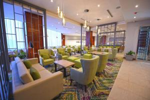 a waiting room with couches and tables and windows at Hilton Garden Inn Kampala in Kampala