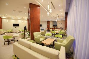 ein Wartezimmer mit Sofas, Tischen und Stühlen in der Unterkunft Hilton Garden Inn Kampala in Kampala