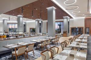 a restaurant with tables and chairs and a bar at Doubletree By Hilton Canakkale in Canakkale