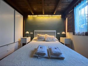 a bedroom with a large bed with towels on it at Acogedora casa rural en la sierra de Madrid in Mataelpino