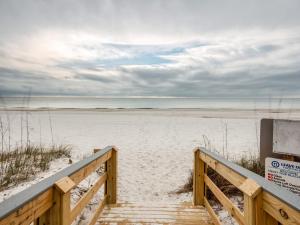 a wooden staircase leading to a sandy beach at Summer House 103A by Vacation Homes Collection in Orange Beach