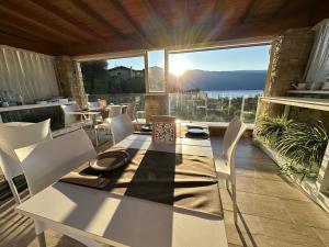 een tafel en stoelen op een balkon met uitzicht op de oceaan bij La Cascata Negli Ulivi in Toscolano Maderno